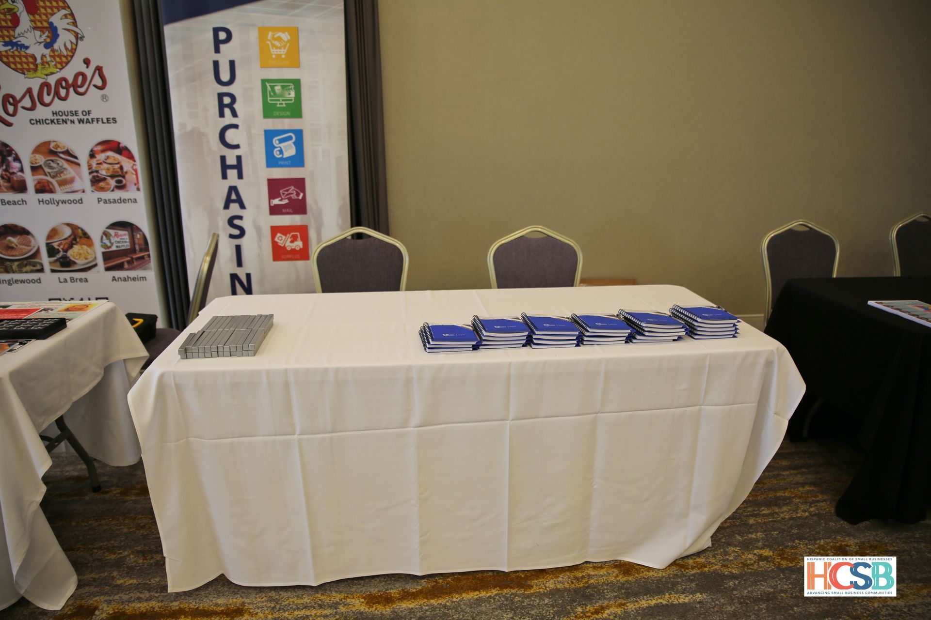 A table with a white table cloth and a sign that says purchase in the background.