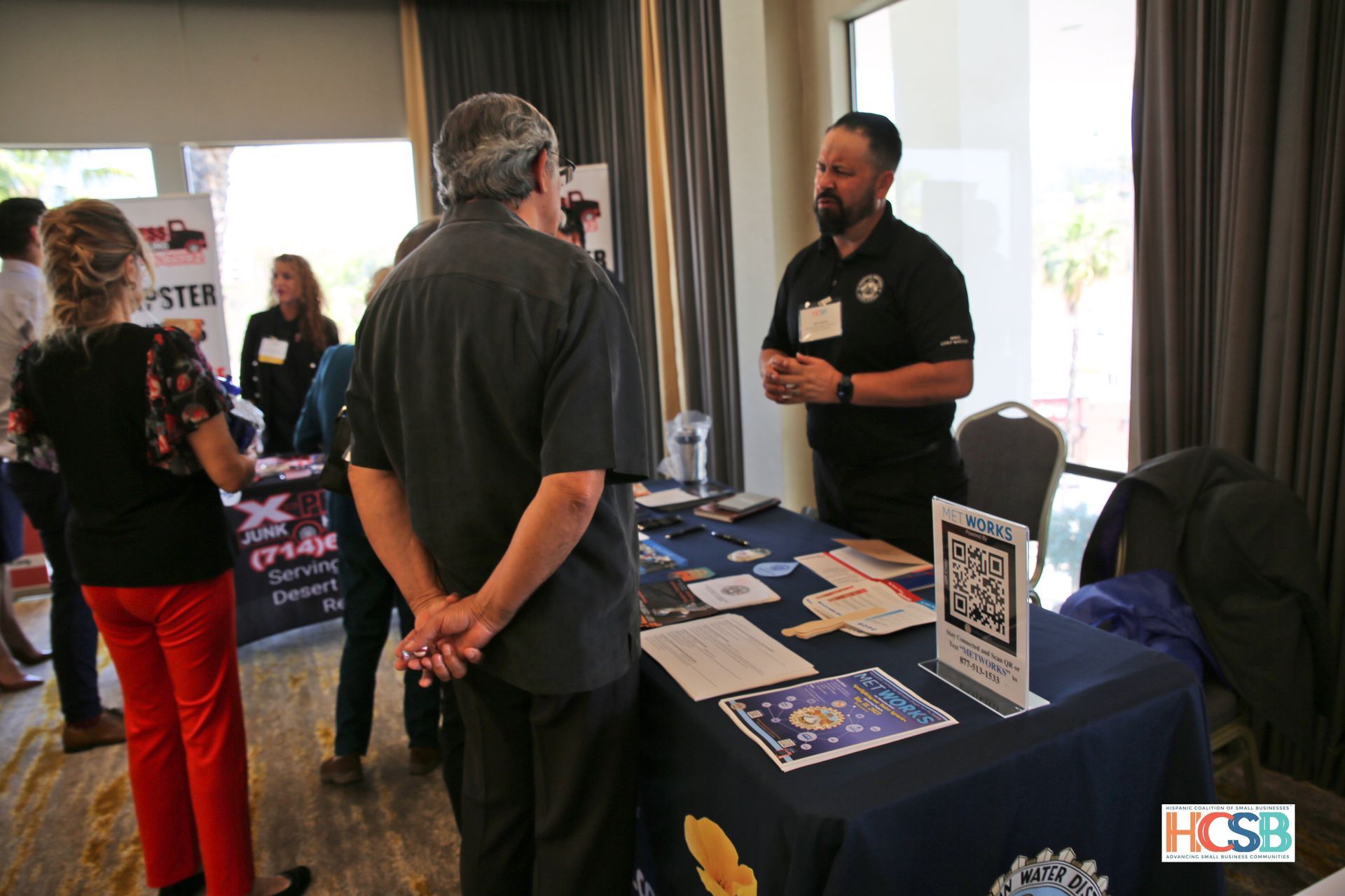 A group of people are standing around a table at a job fair.
