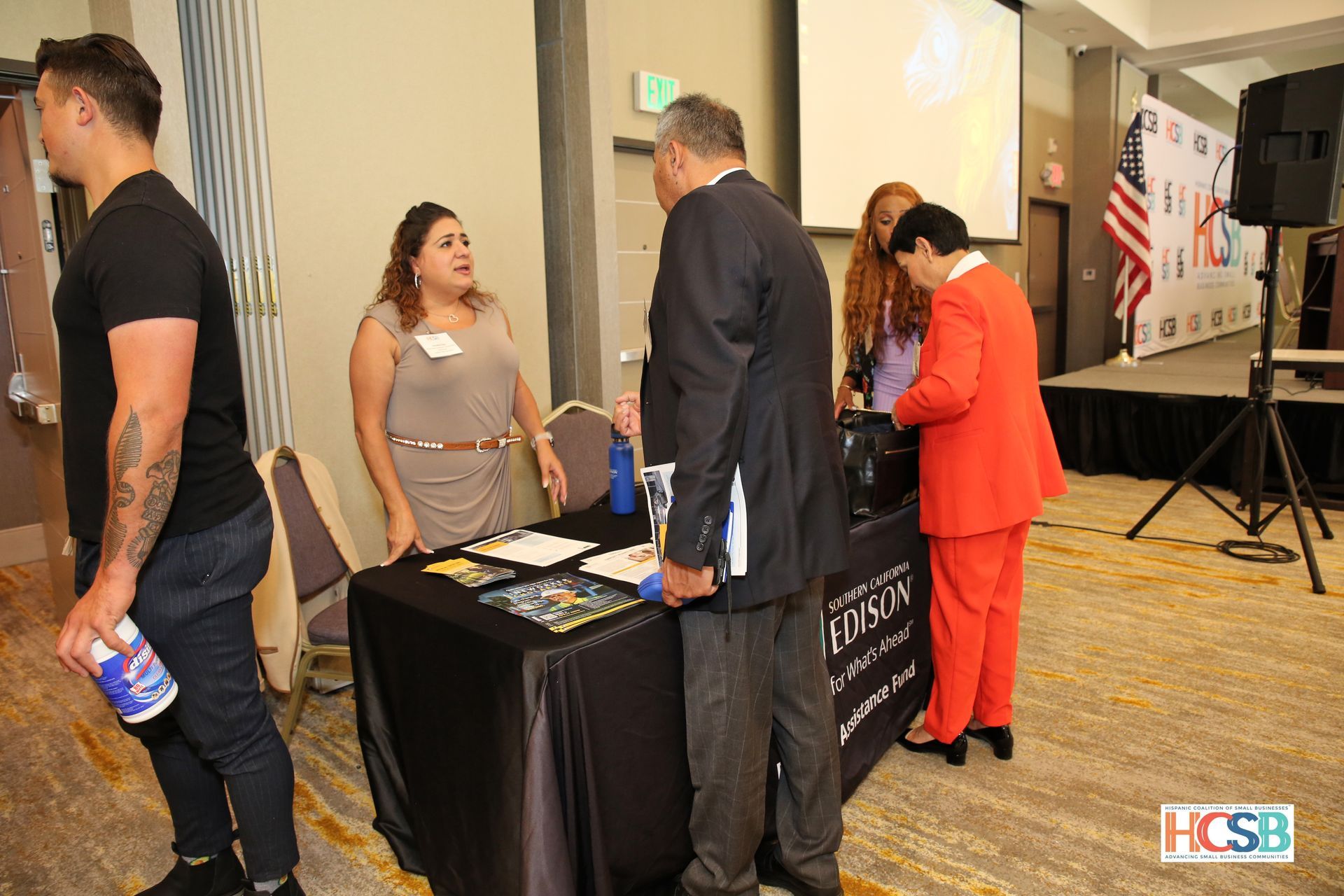 A group of people are standing around a table at a conference.