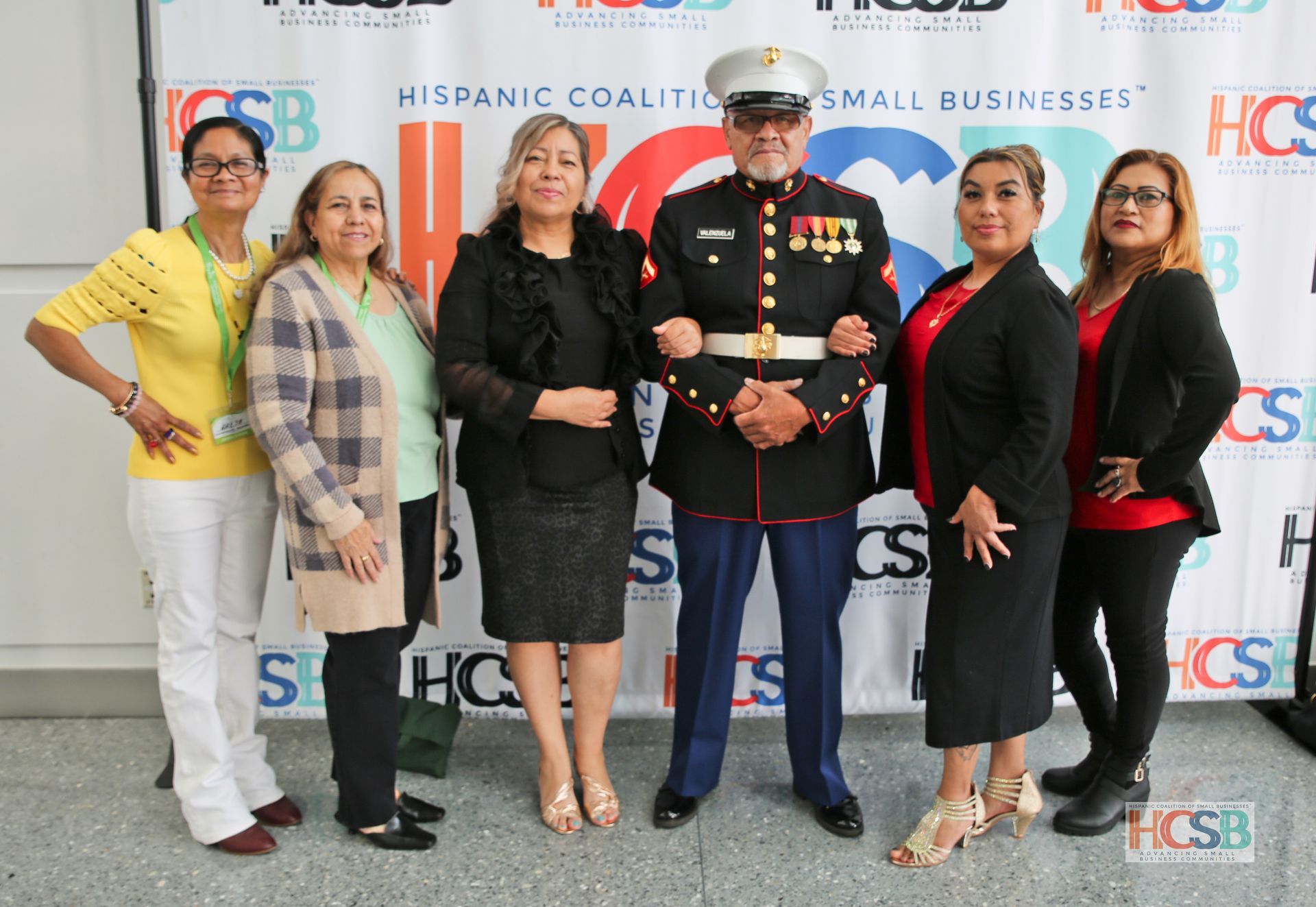 A group of women standing next to a man in a marine uniform