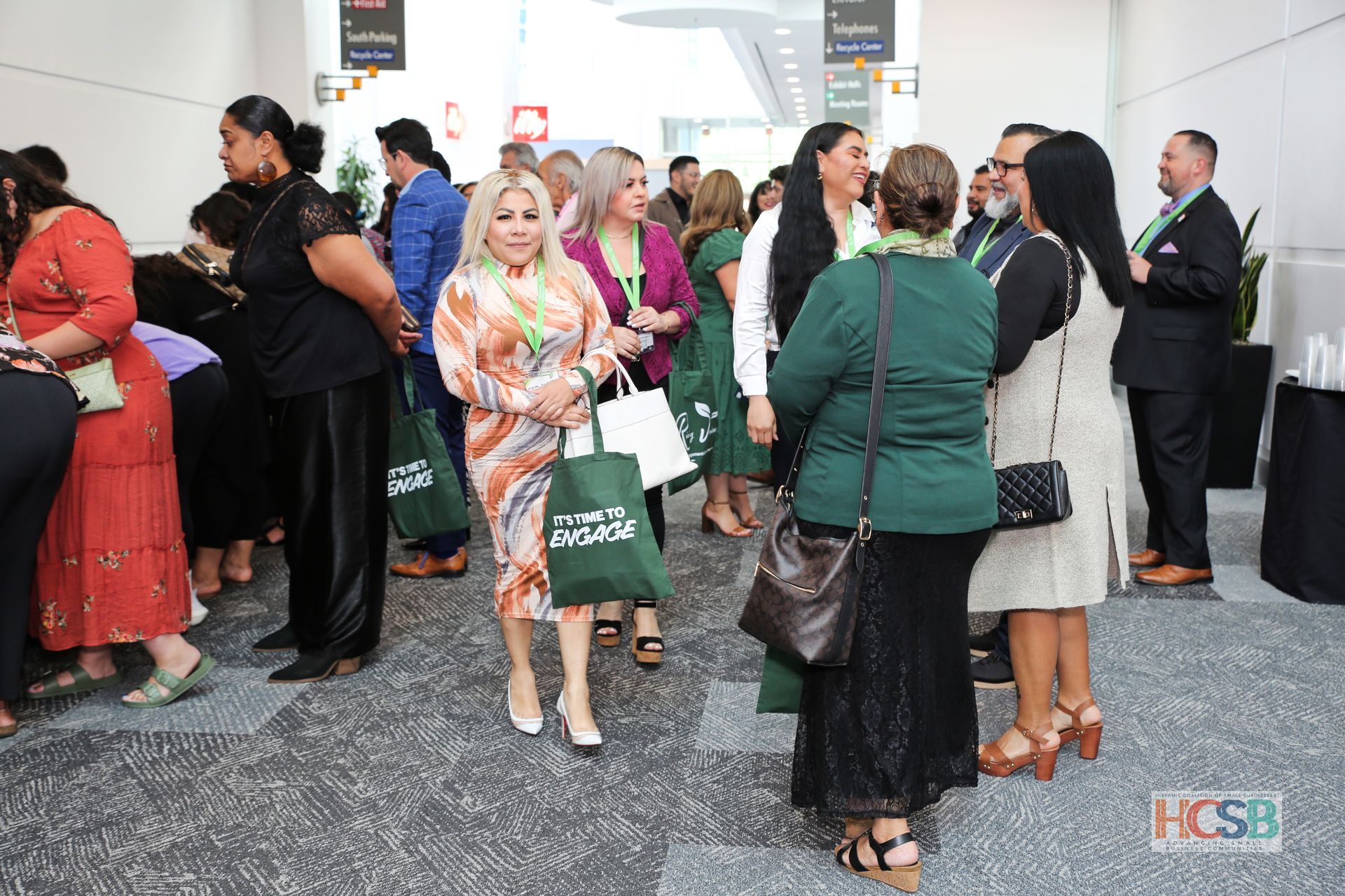 A group of women are standing in a hallway talking to each other