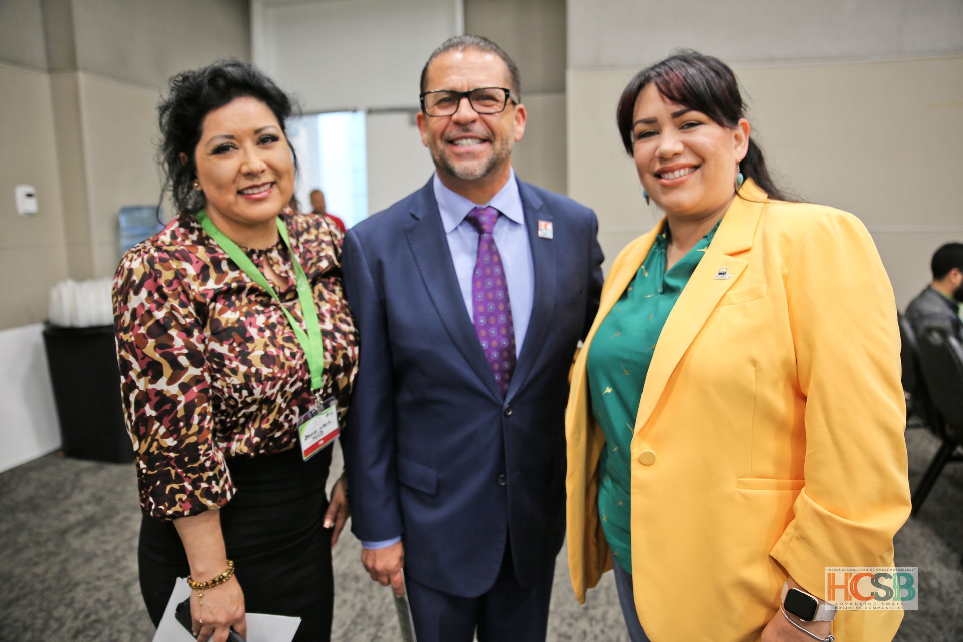 A man in a suit and tie poses with two women