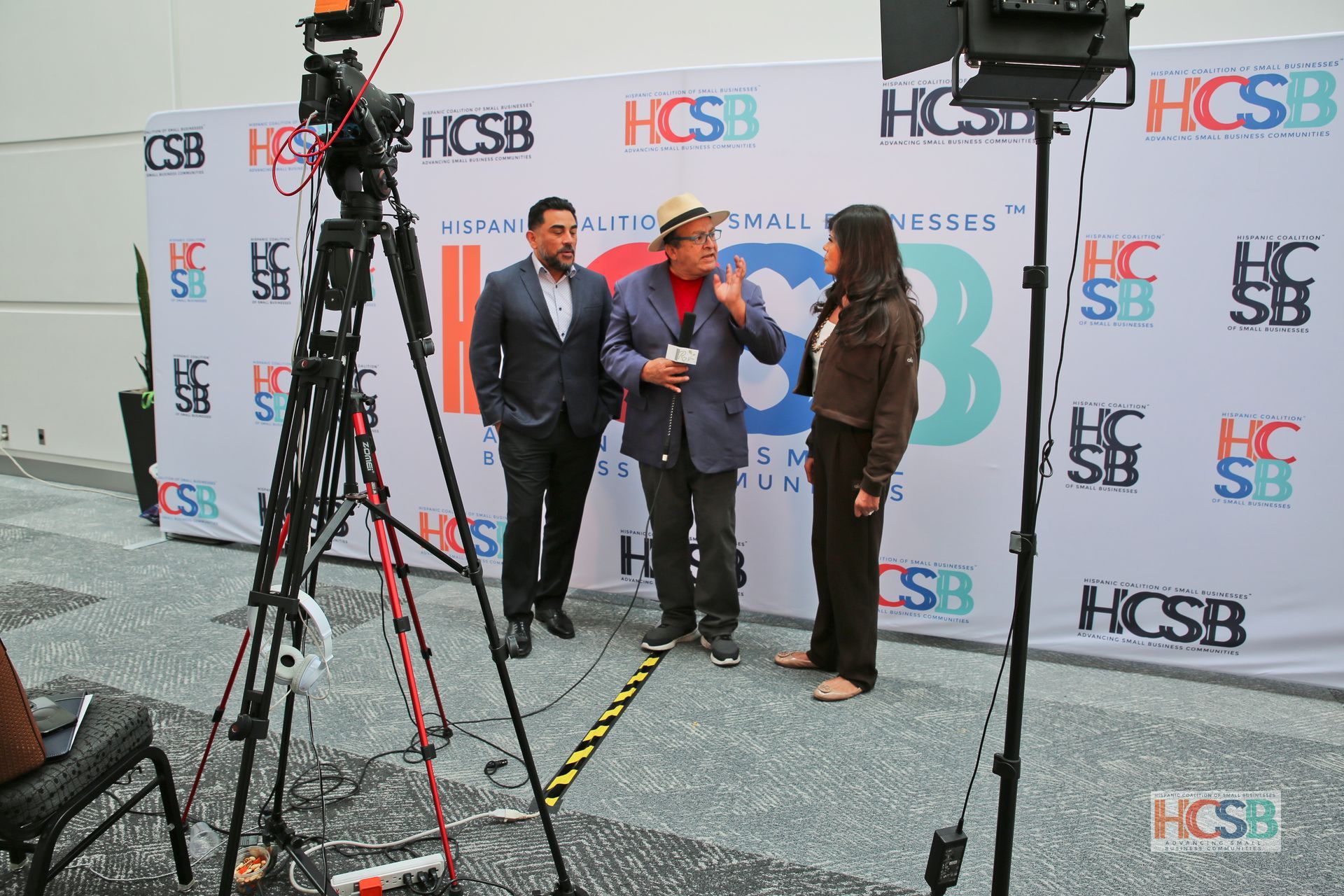 A group of people are standing in front of a wall that says hcsb