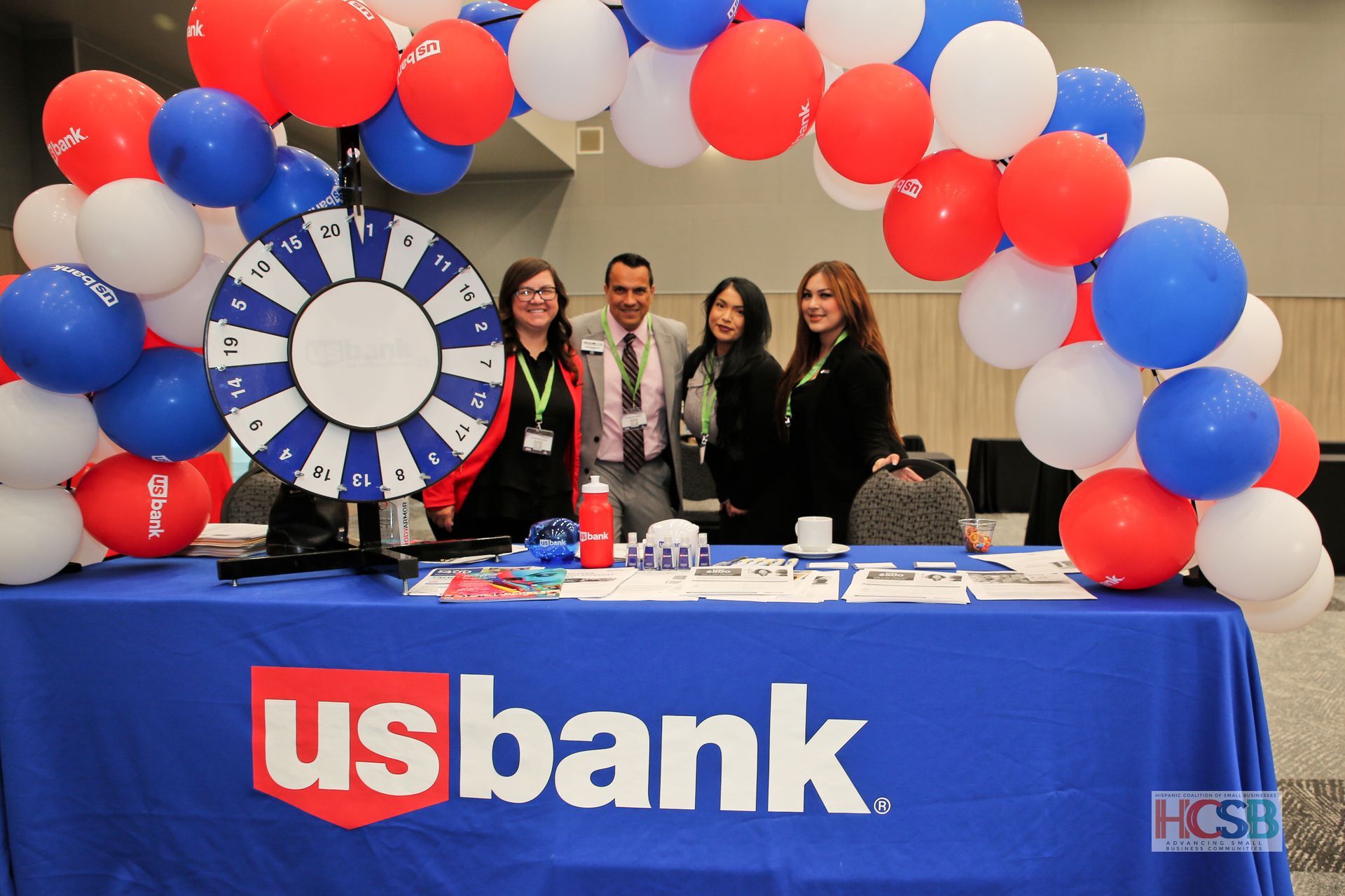 A group of people standing around a table that says us bank