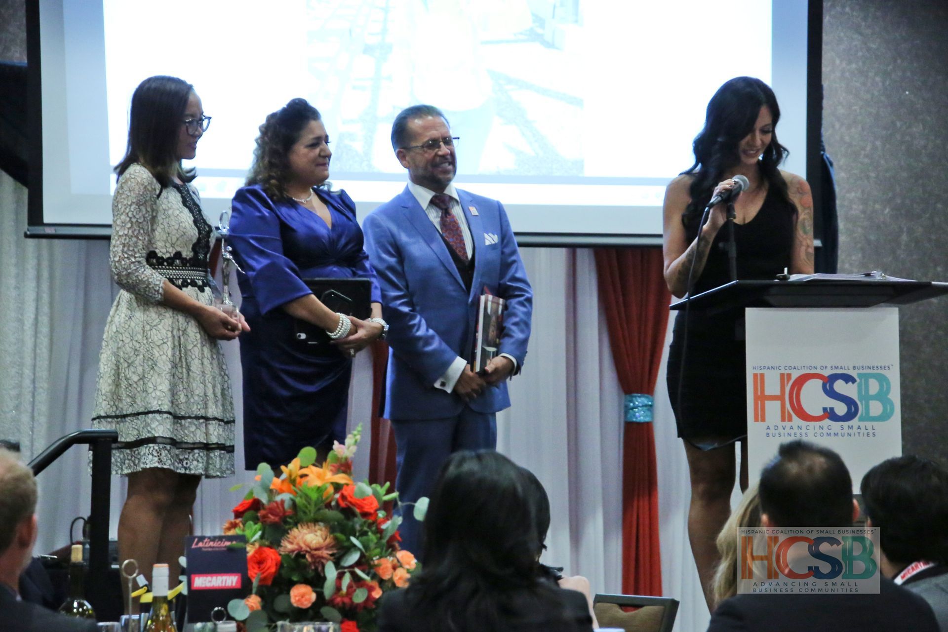 A group of people standing in front of a podium that says hcsb