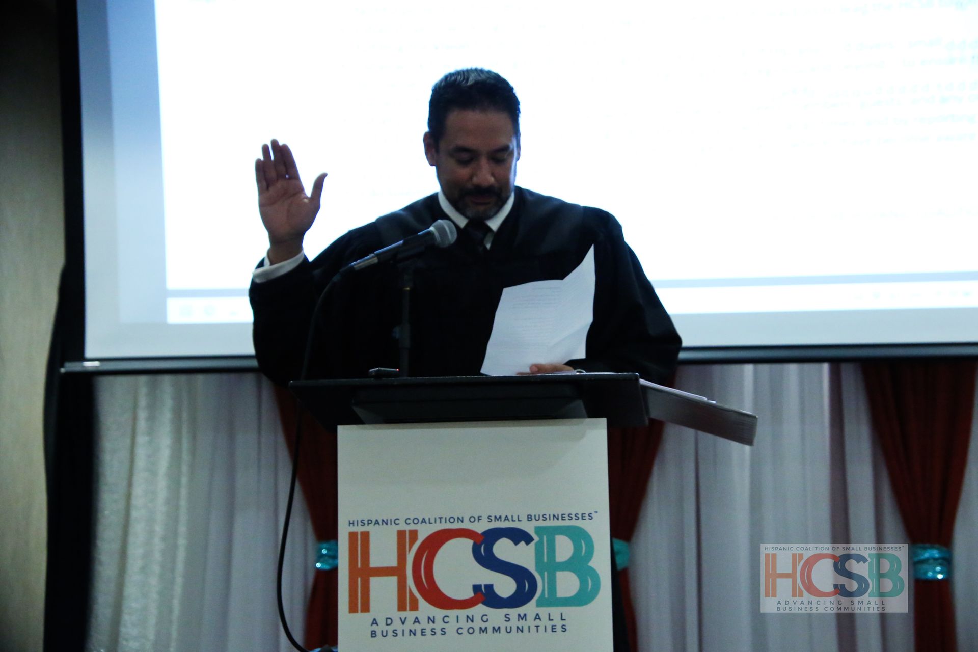 A man stands at a podium that says hcsb on it