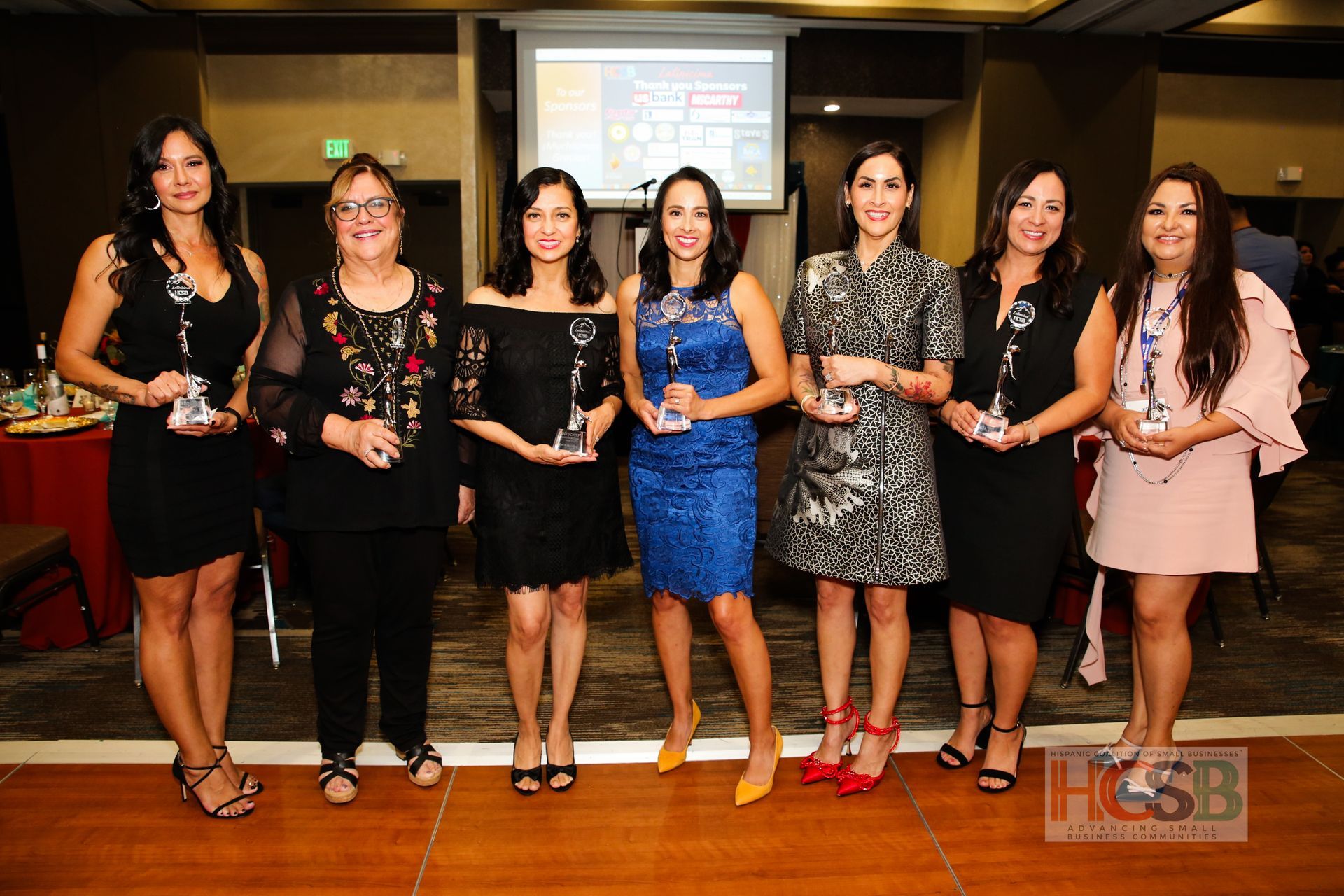 A group of women standing next to each other holding trophies.