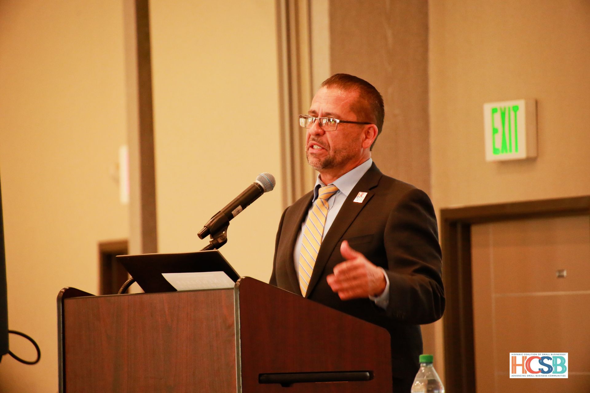 A man in a suit and tie is standing at a podium giving a speech.