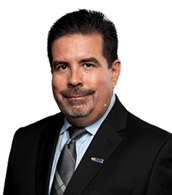 A man in a suit and tie is smiling for the camera.