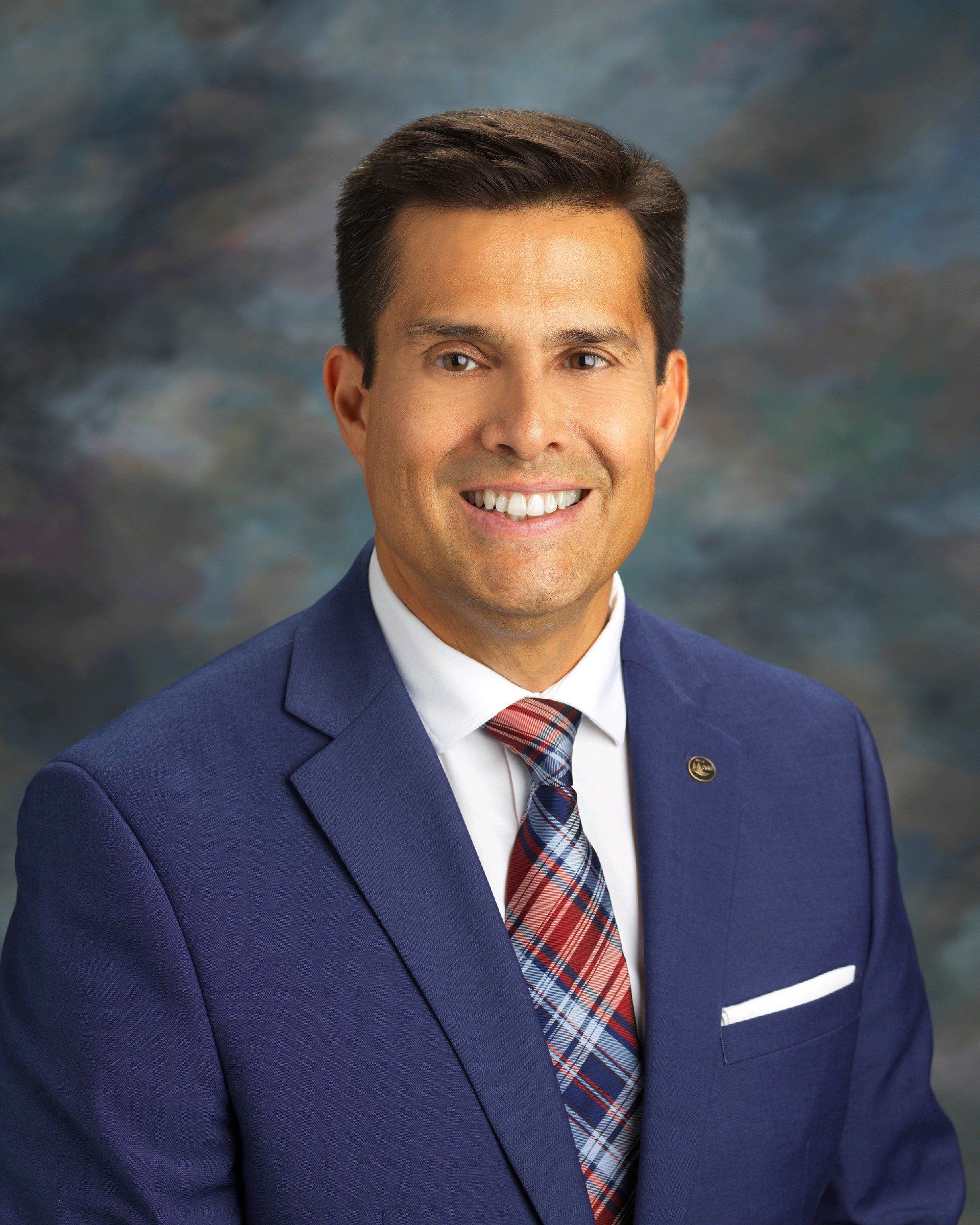 A man in a suit and tie is smiling for the camera.