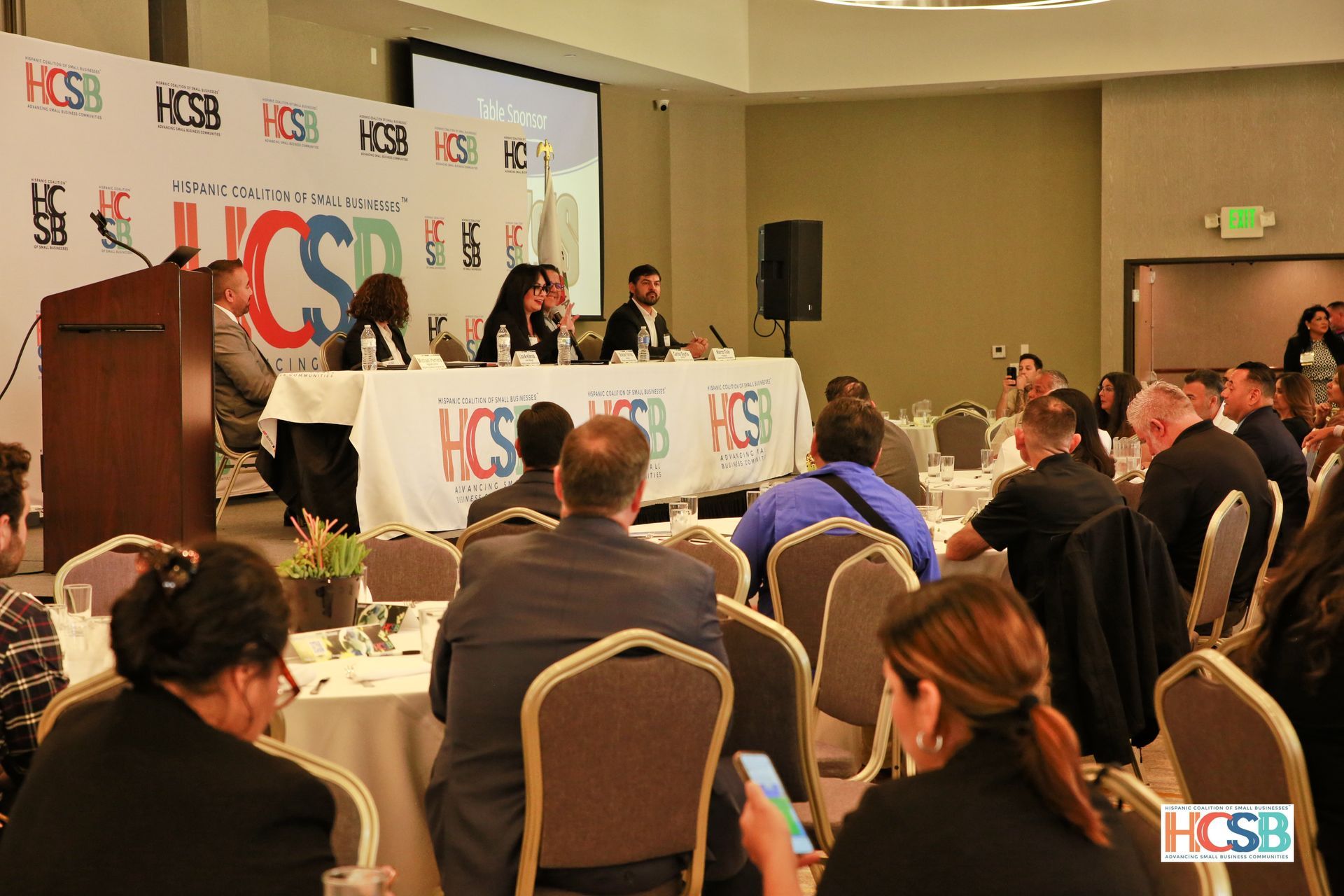 A group of people are sitting at tables at a conference.