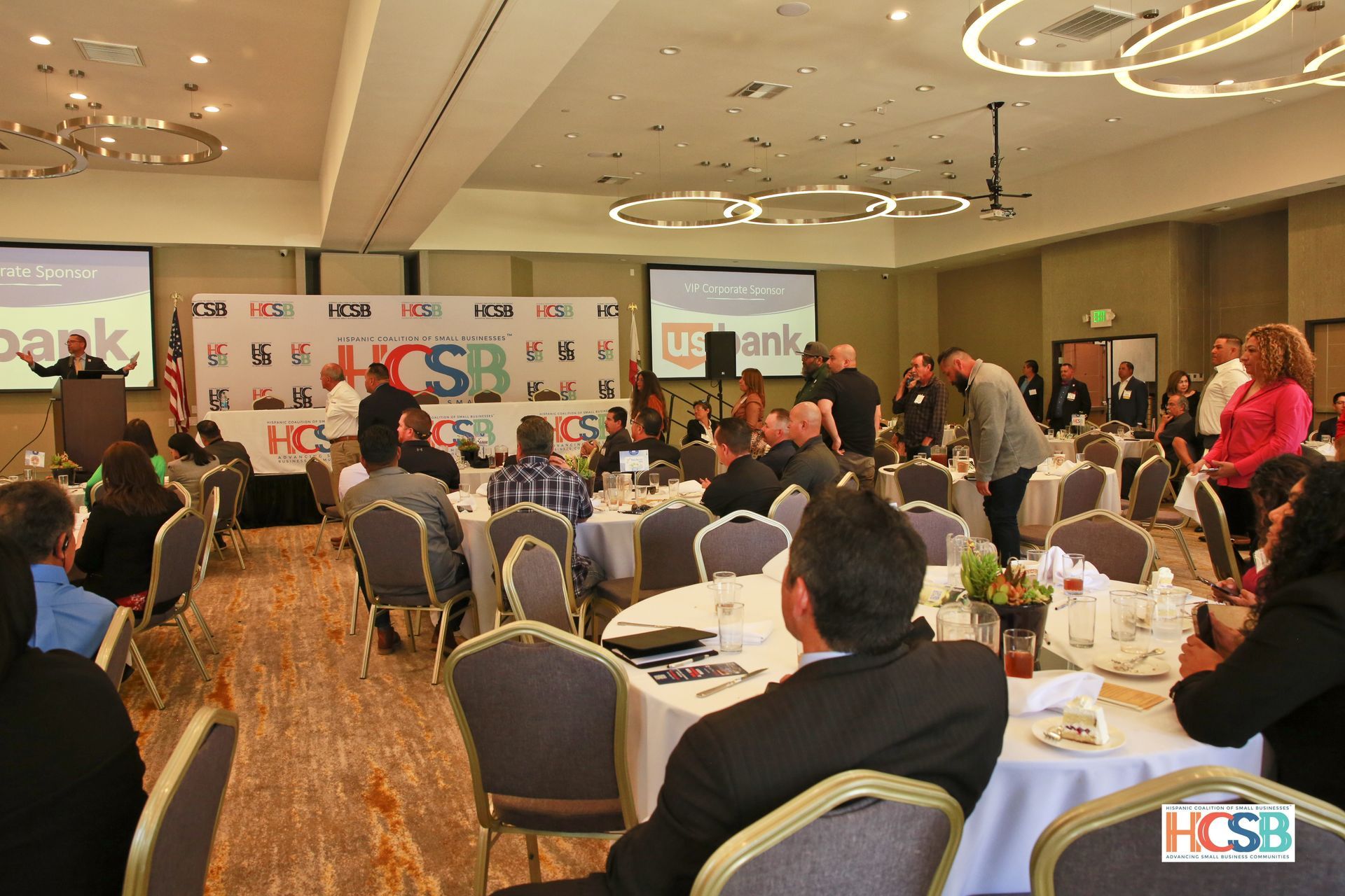 A group of people are sitting at tables in a large room.