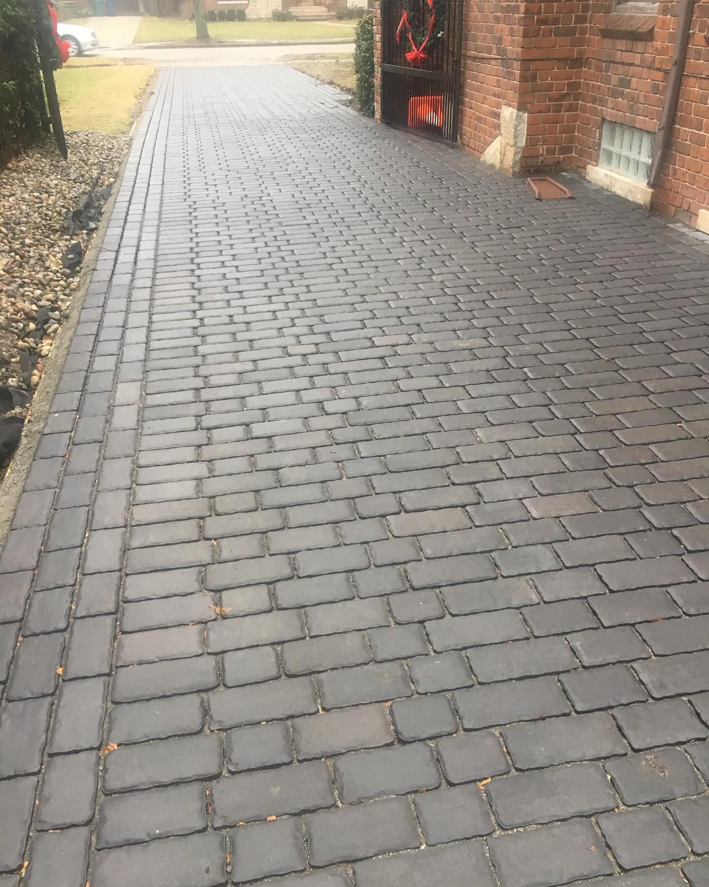 a brick walkway going through a garden surrounded by bushes .