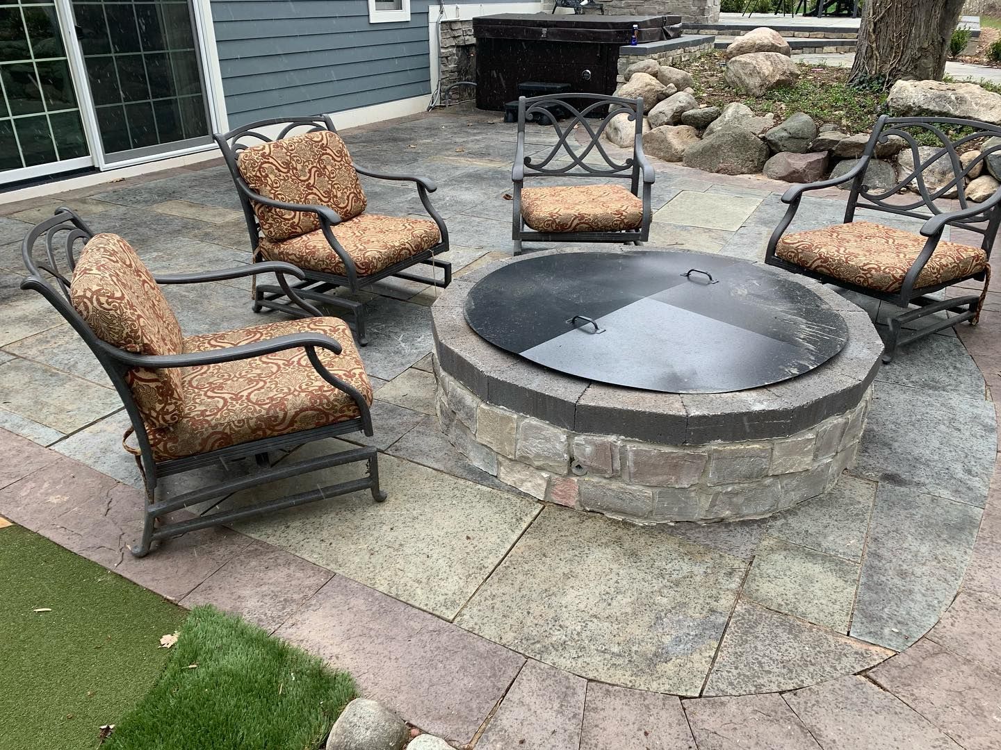 there is a fire pit in the middle of the patio .
