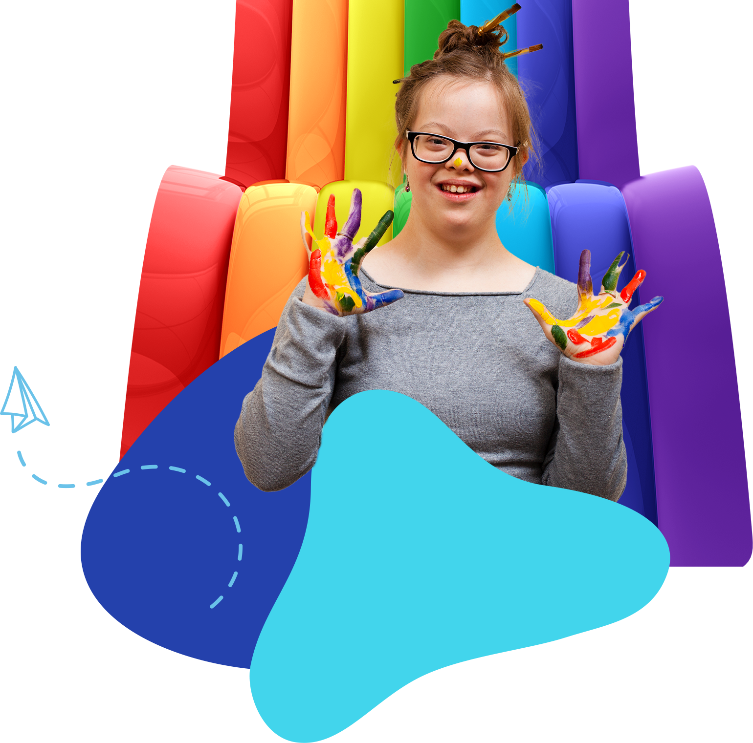 Smiling person with rainbow paint on hands in front of a colorful inflatable slide