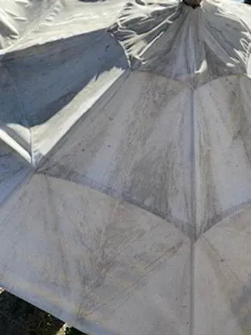 Close-up of a white and silver tent or canopy with folded fabric panels.