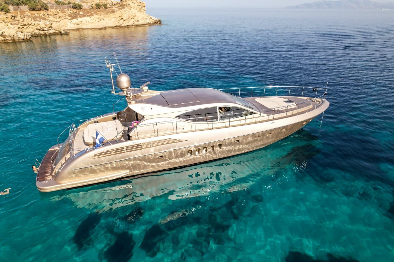 Zeus motor yacht cruising turquoise waters for a private yacht charter in Mykonos