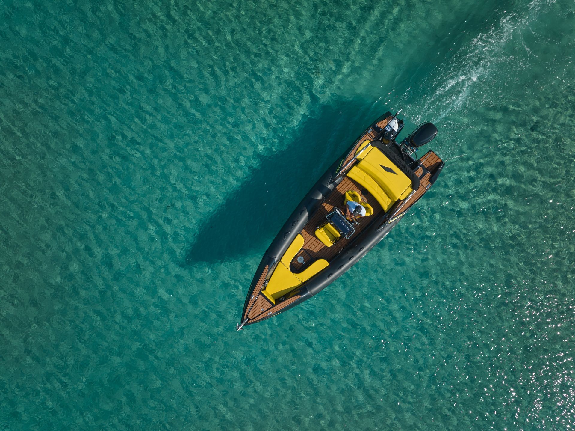 Yellow RIB speedboat cruising in crystal-clear waters in Mykonos