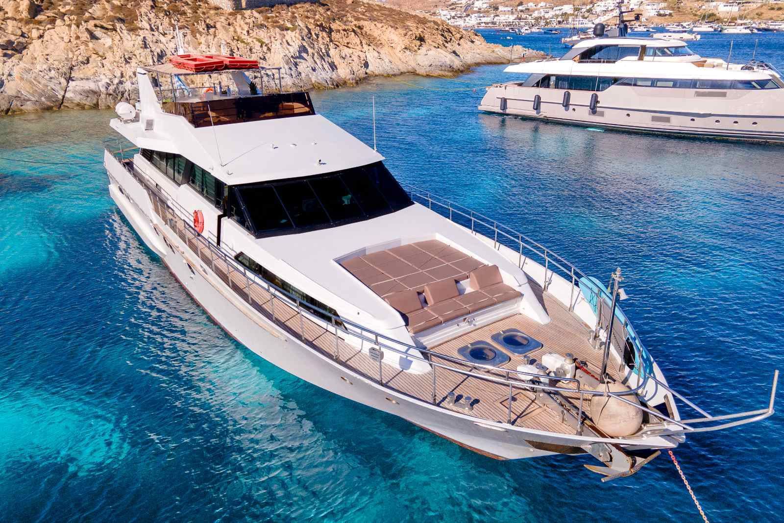 Luxury motor yacht anchored in crystal-clear waters for a private yacht charter in Greece