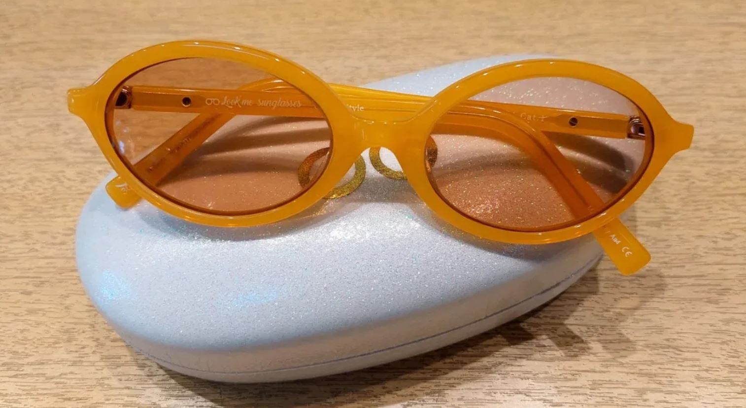 Vasos naranjas descansando sobre una funda de espuma blanca sobre una superficie de madera.