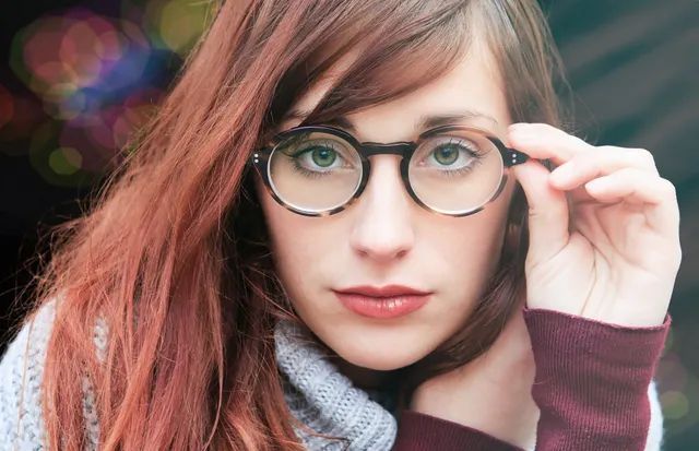 Dos pares de gafas, una negra y otra azul, descansan sobre un libro marrón