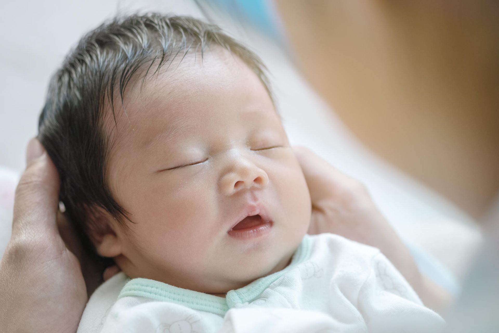 bably sleeping comfortably in the mother's arms