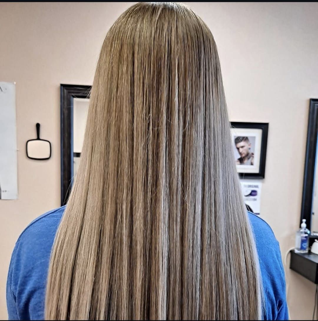 Back view of long, straight blonde hair in a salon setting