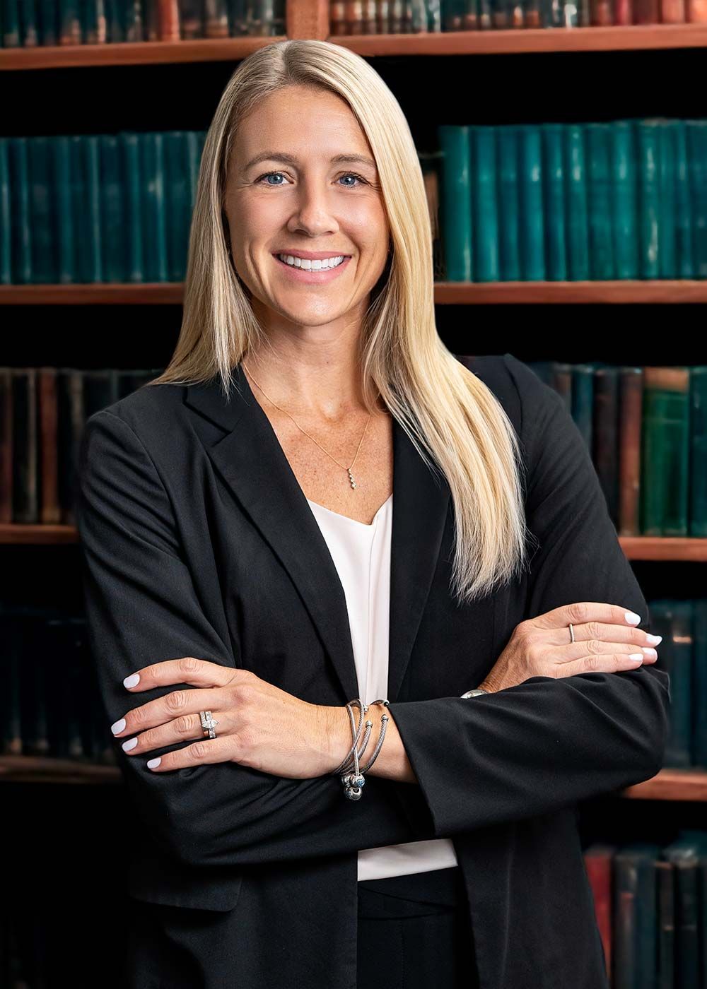 A woman in a black shirt is standing with her arms crossed.