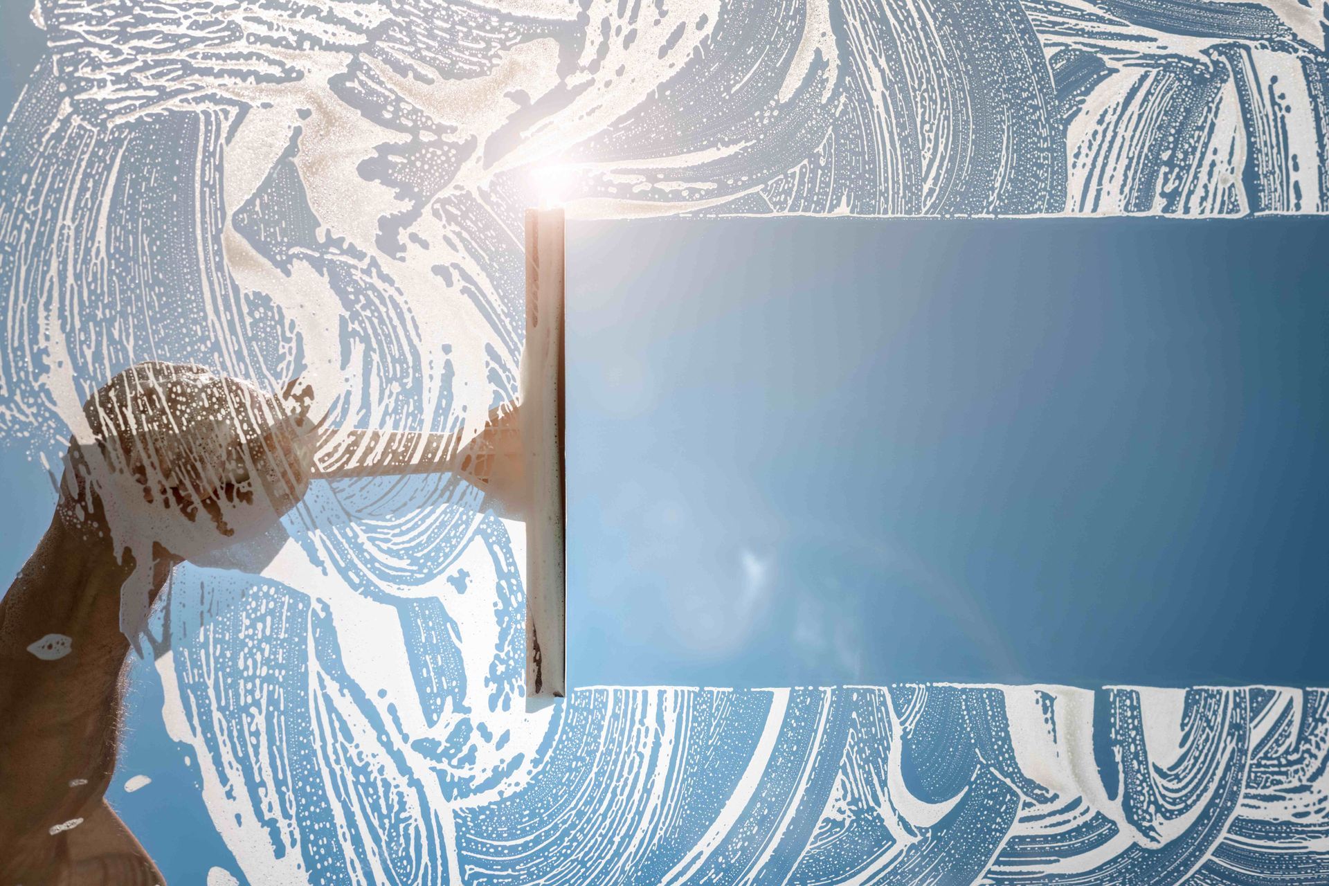 a person is cleaning a window with a squeegee