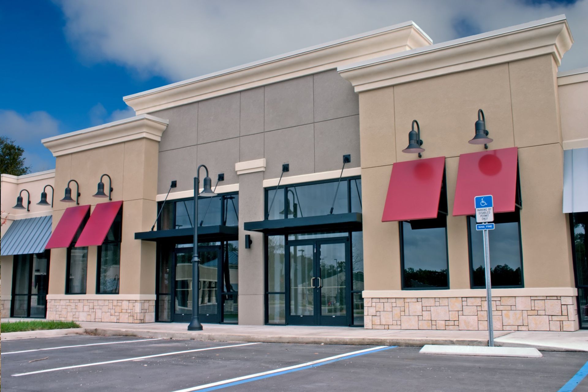 a building with red awnings and a handicapped parking sign