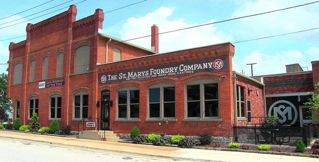 Red brick historic building with a mural sign reading “The St. Marys Foundry Company” on a sunny street.
