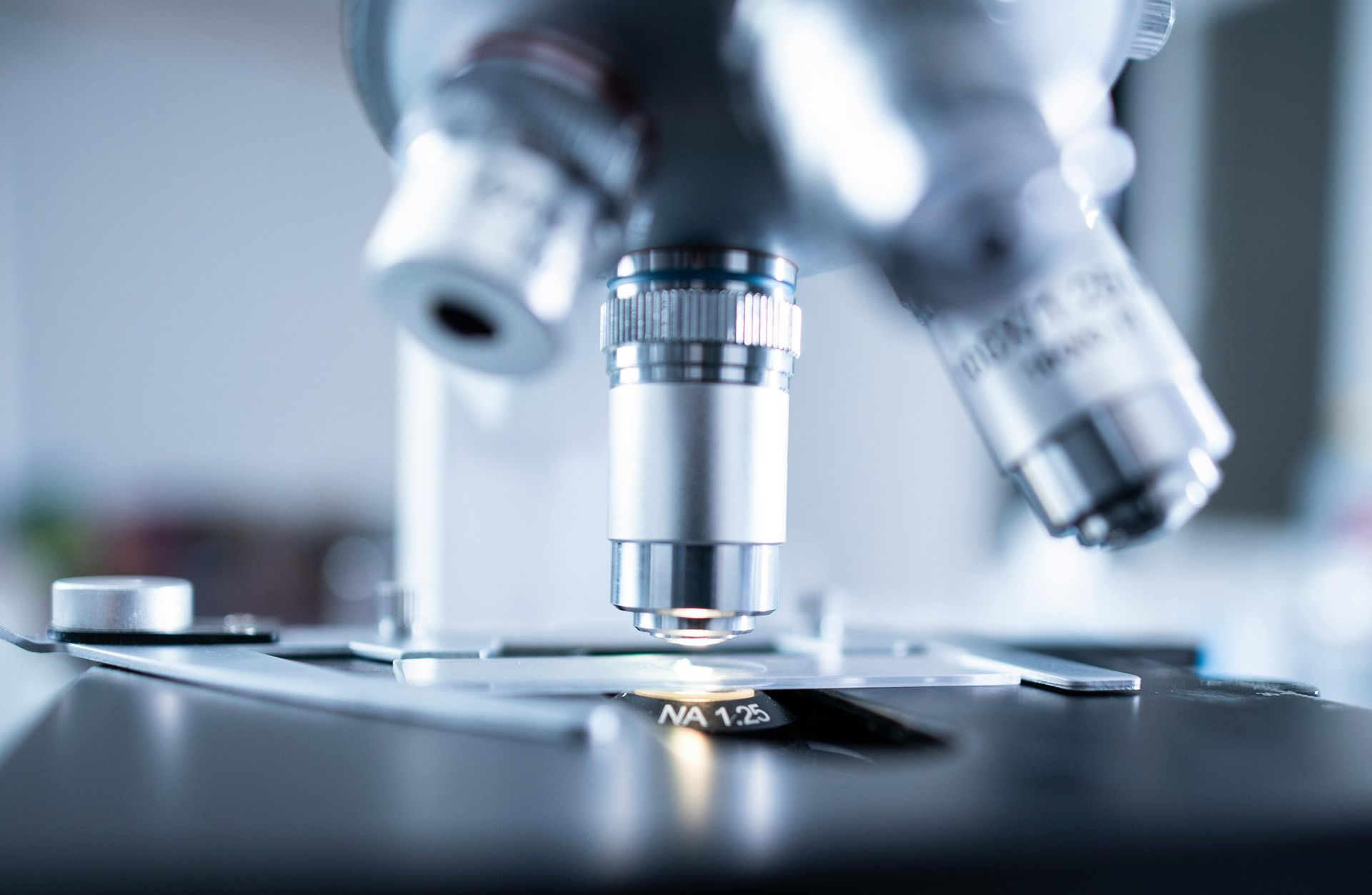 Microscope close-up examining a lab slide in a bright scientific setting