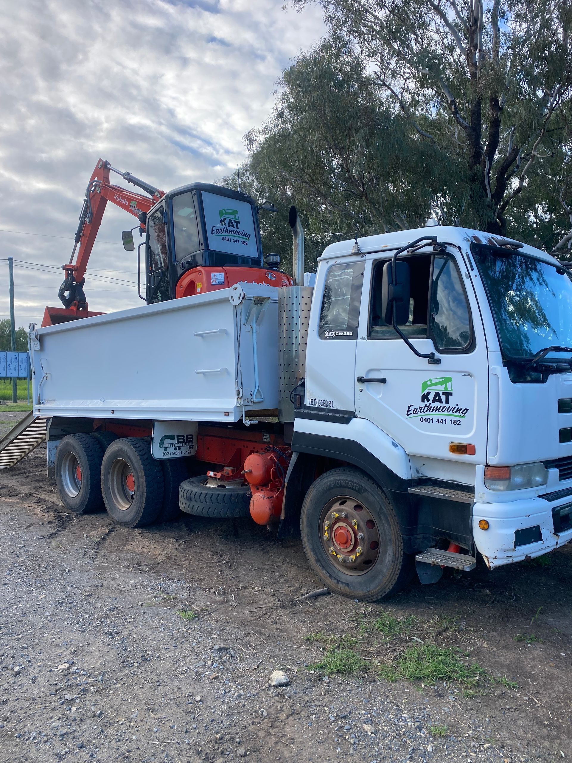 Tractor pushing leaves in a wooded area with red and orange foliage — KAT Earthmoving In Nine Mile, QLD