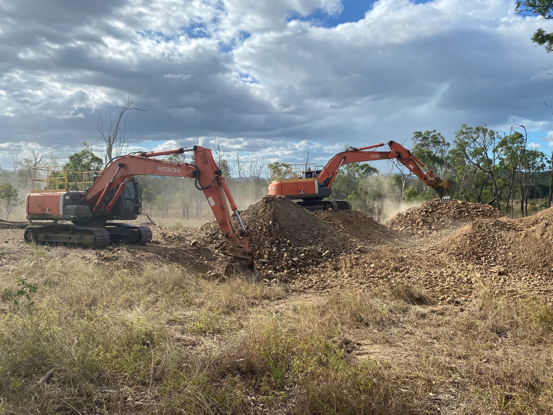 Yellow Excavator on A Dirt Construction Site Against a Cloudy Blue Sky — KAT Earthmoving In Nine Mile, QLD