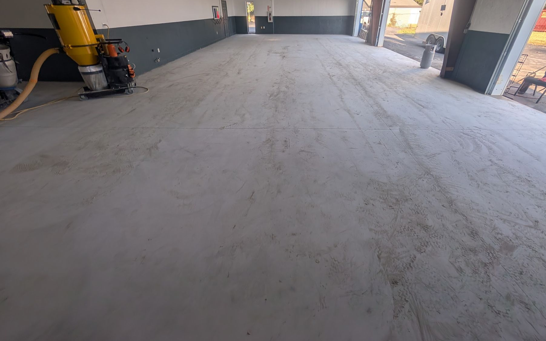A large house with two garage doors and a concrete driveway.