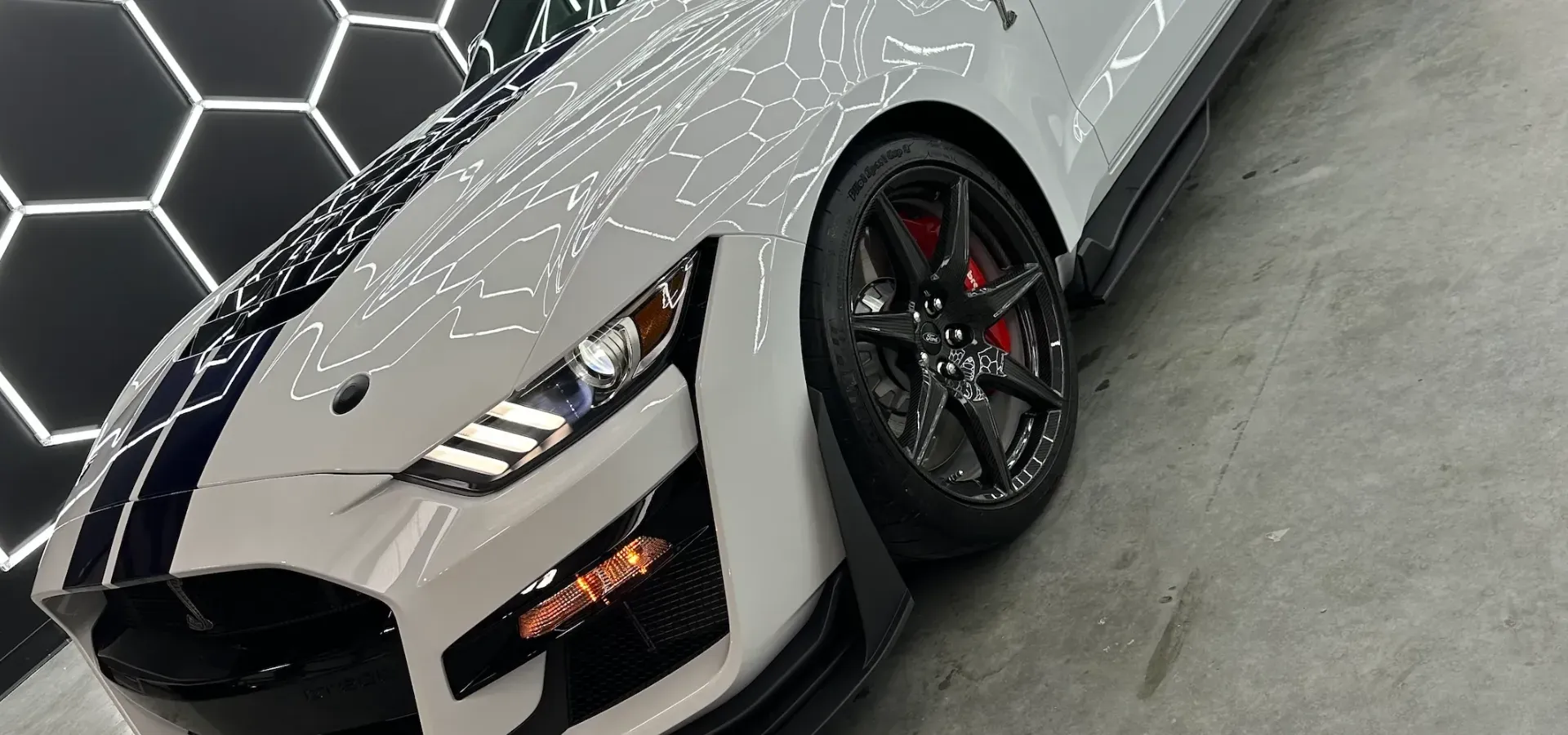 A gray audi e-tron is parked in front of a garage door.