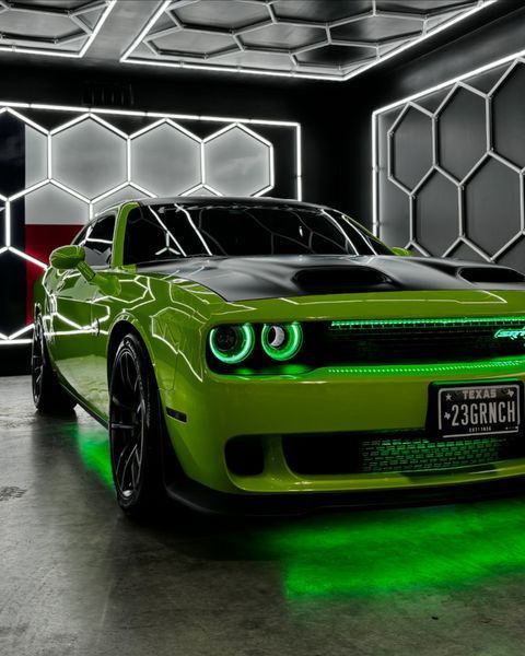 Green sports car with neon underglow in a futuristic garage