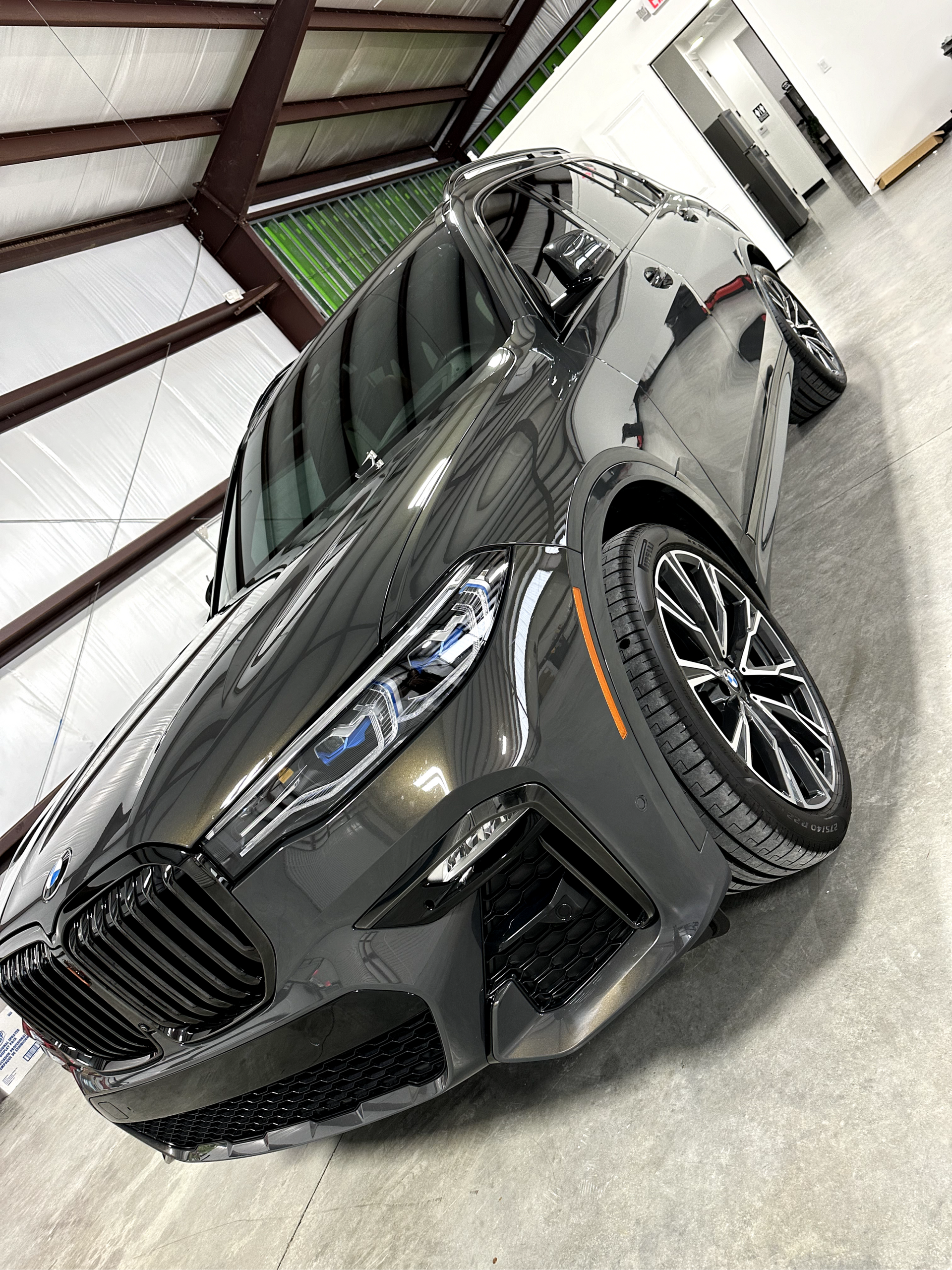Gray SUV parked in a showroom, viewed from a low angle with a modern industrial interior.