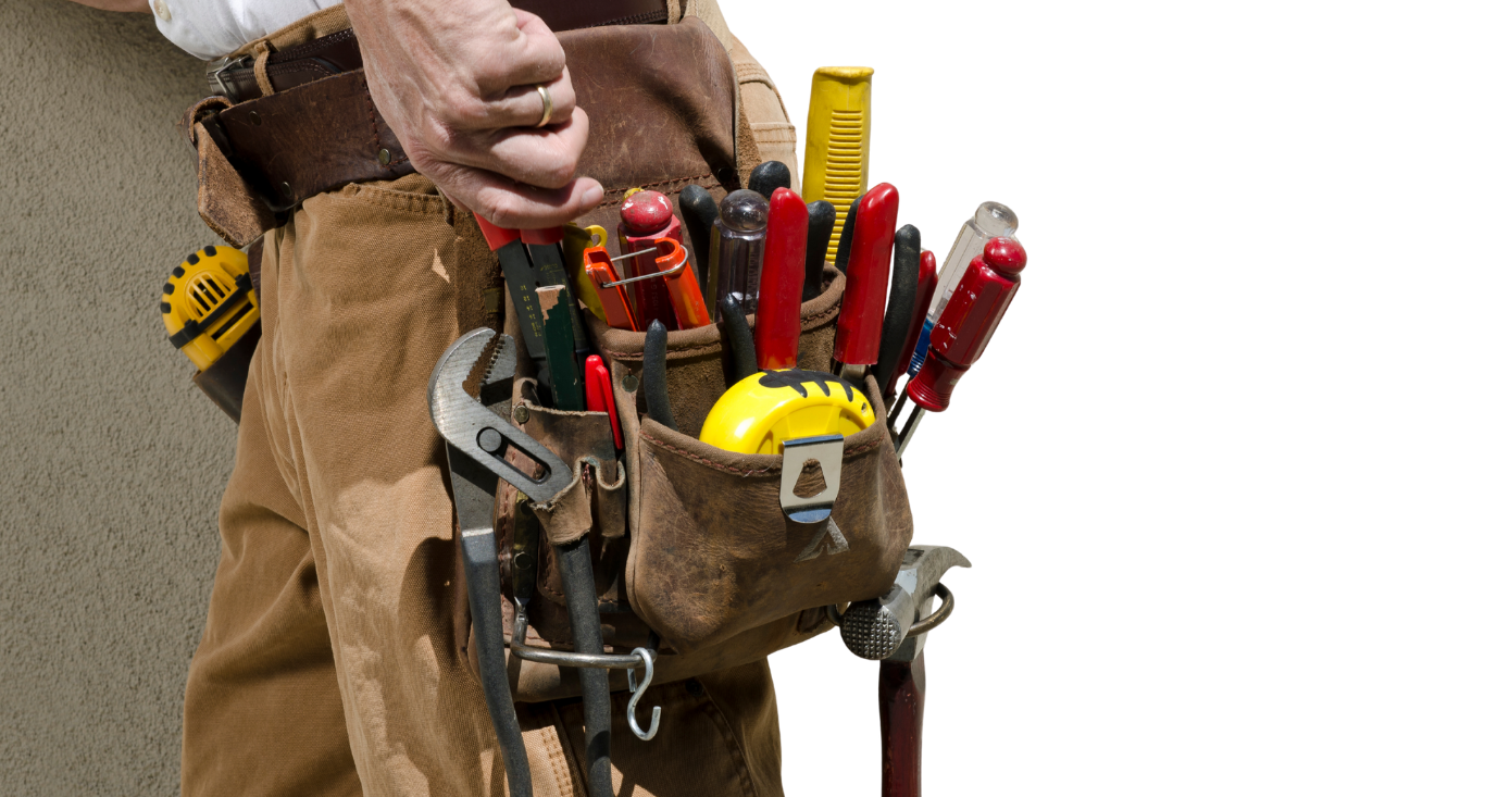 Close-up of a tool belt with screwdrivers, pliers, and other hand tools on a worker’s waist