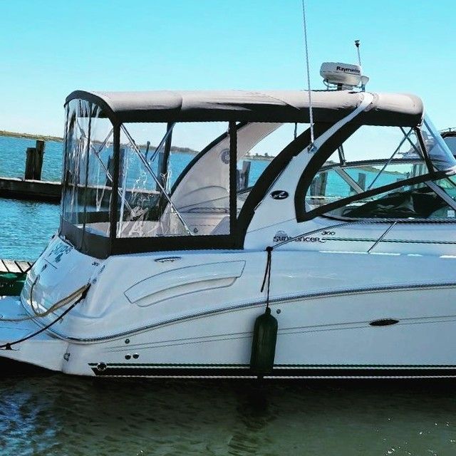 A white boat with a black roof is docked in the water