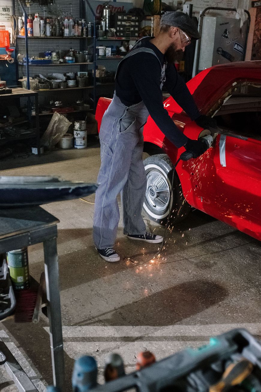 Persona che lucida una Ferrari rossa con una macchina e un tampone giallo.