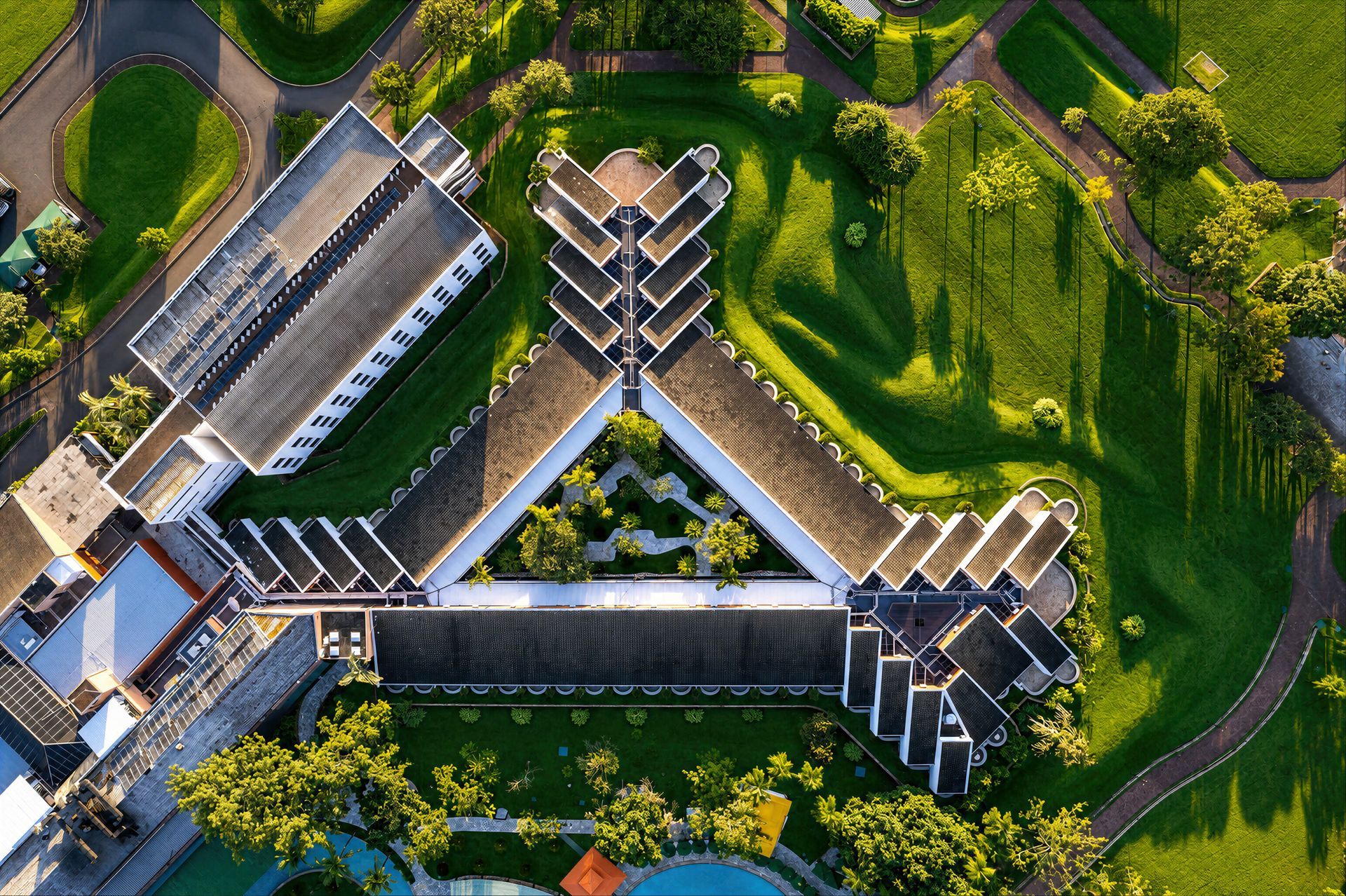 Uma vista aérea de uma grande piscina com um guarda-sol verde.