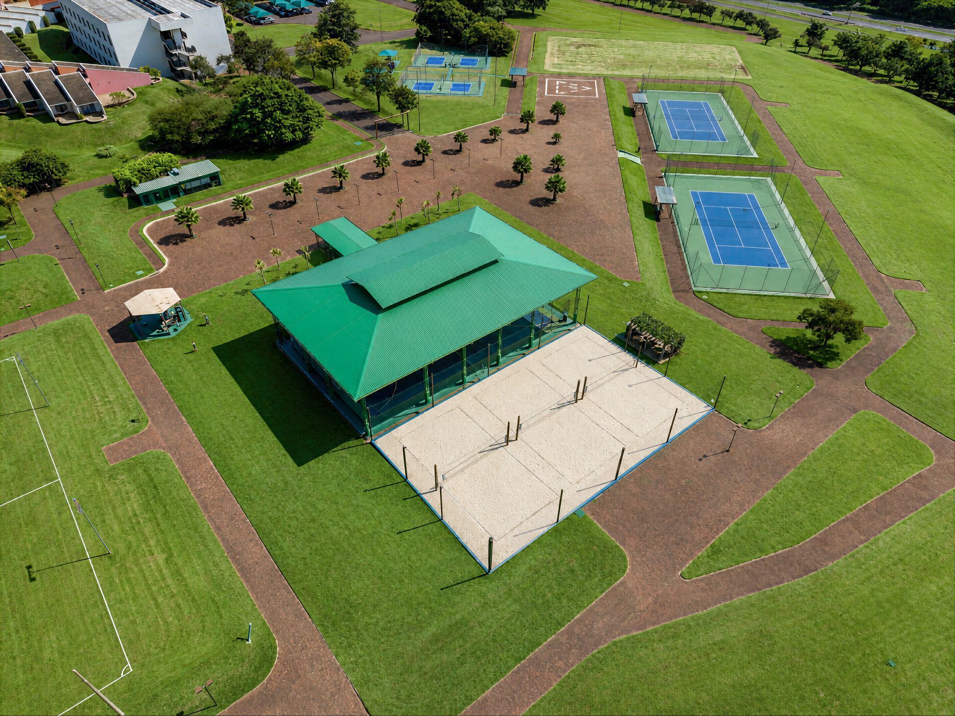 Uma vista aérea de uma casa verde com uma piscina no meio de um campo.