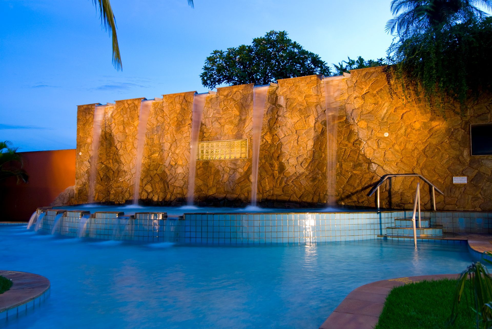 Uma piscina com cascata ao fundo