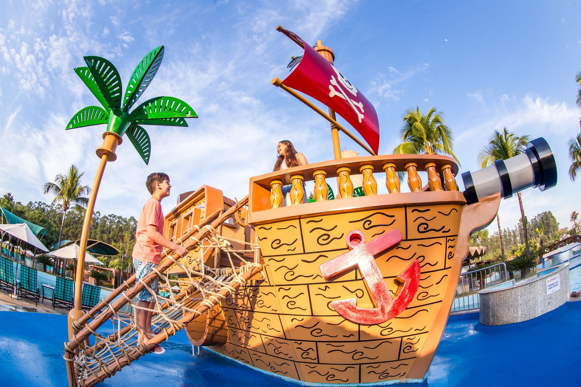 Duas crianças estão brincando em um navio pirata em um parque aquático.