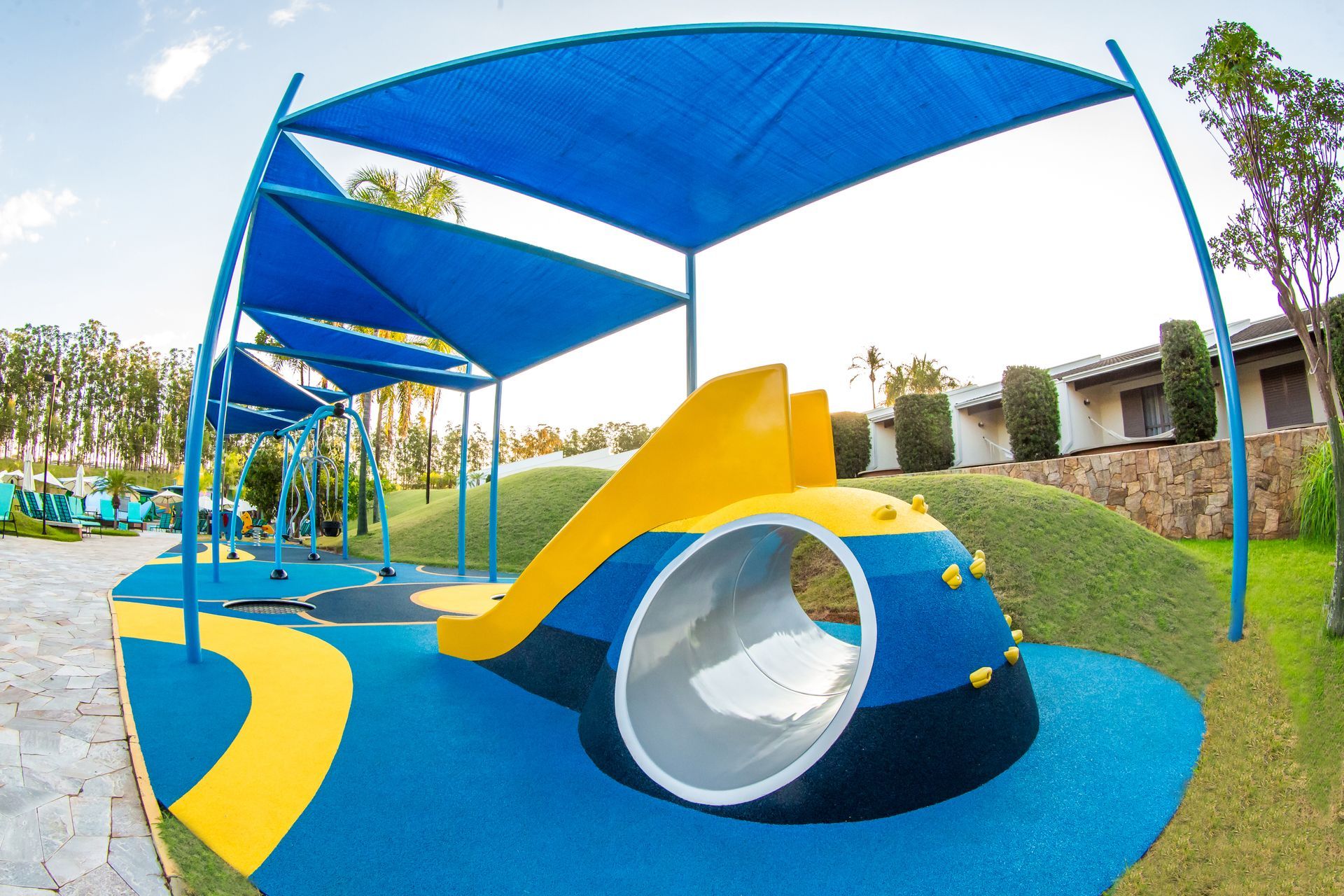 Um playground azul e amarelo com escorregador e túnel