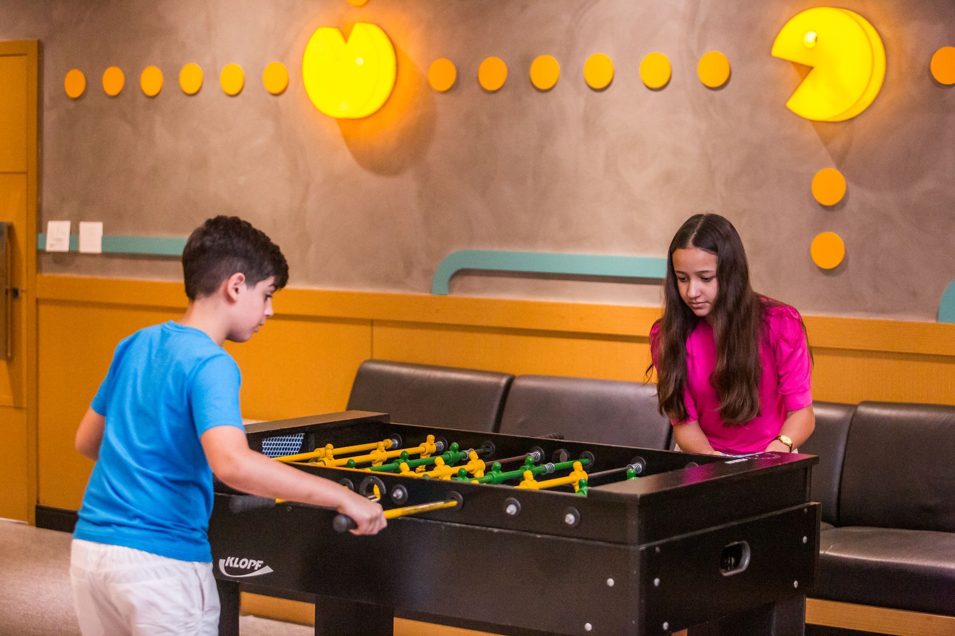 Um menino e uma menina estão jogando pebolim.
