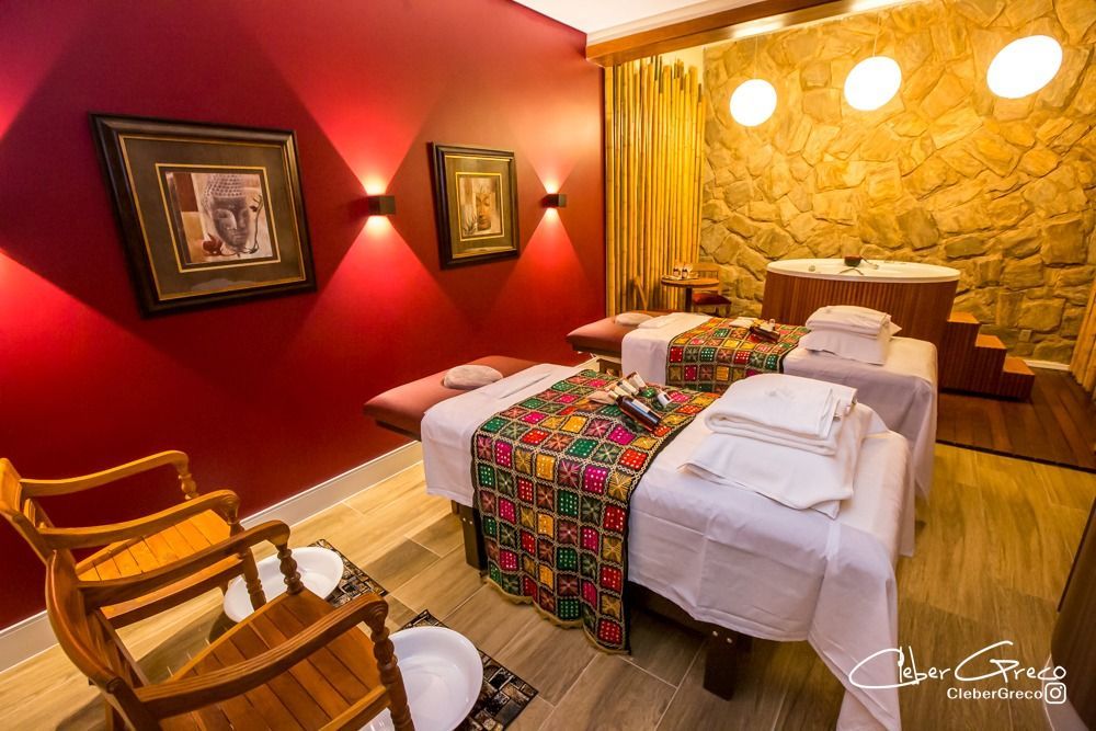 Uma sala com duas mesas de massagem e uma jacuzzi.