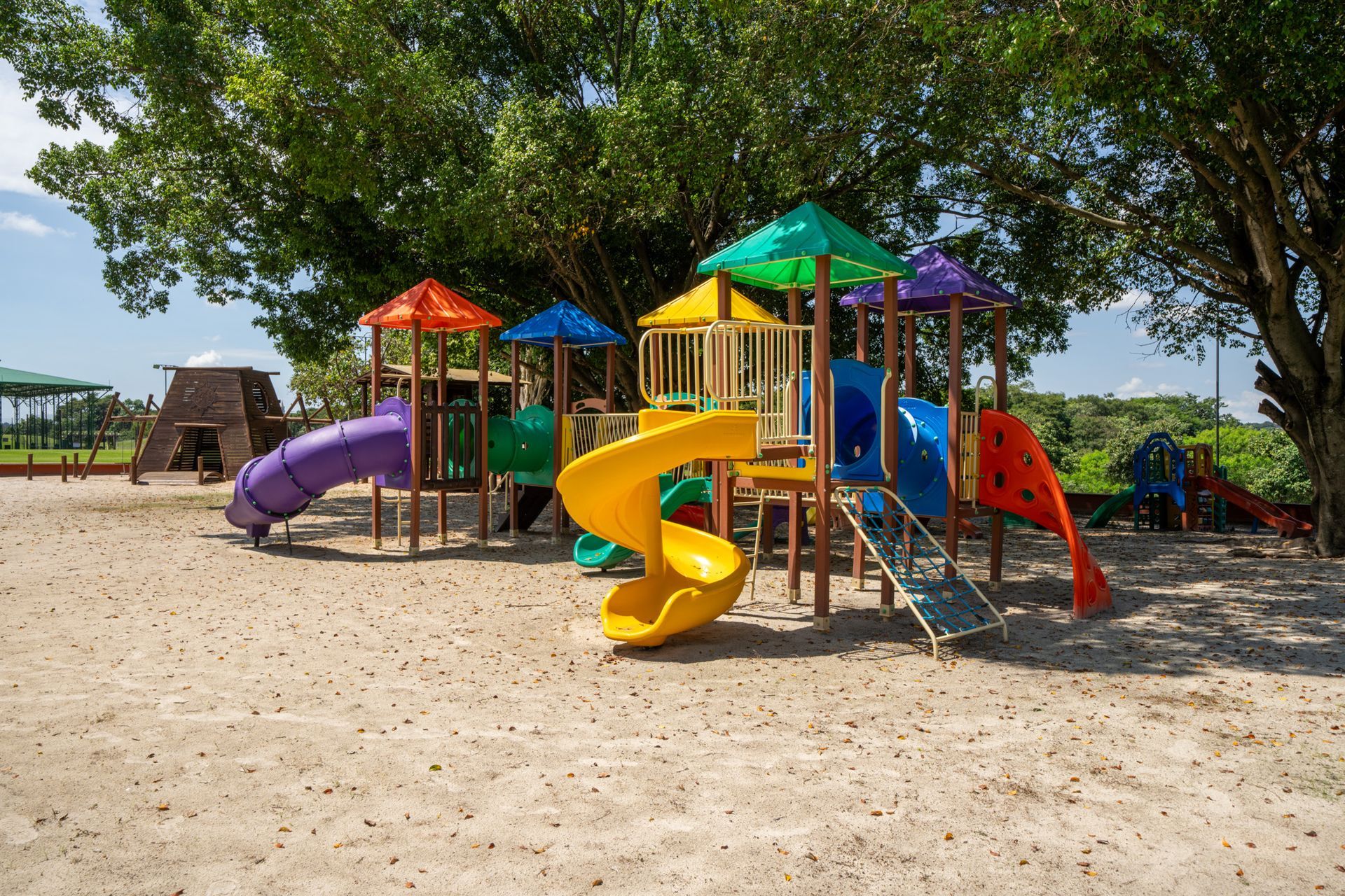 Um playground colorido com uma árvore ao fundo
