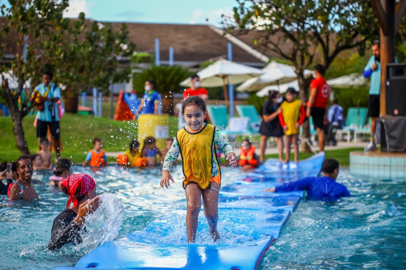 Uma menina está pulando em uma jangada em uma piscina.